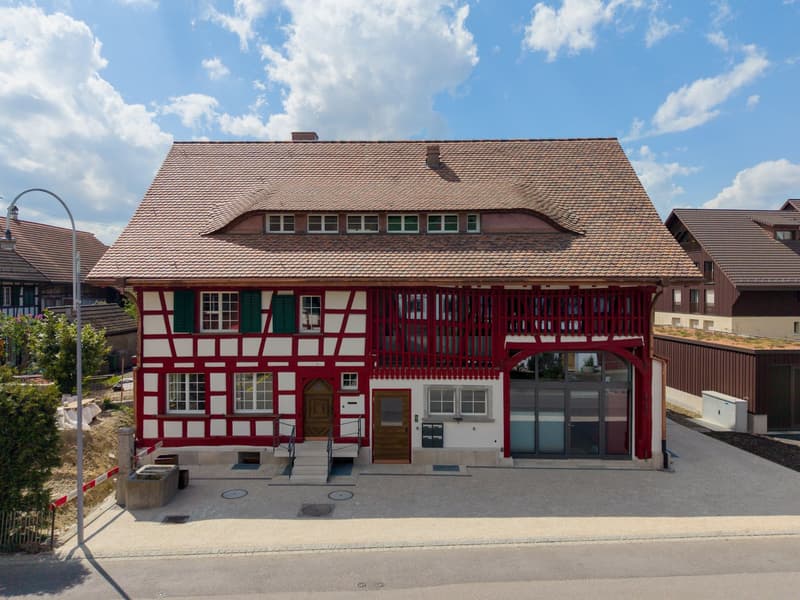 2 story house, red and white exterior, brown roof, multiple windows, two doors, balcony, stairs