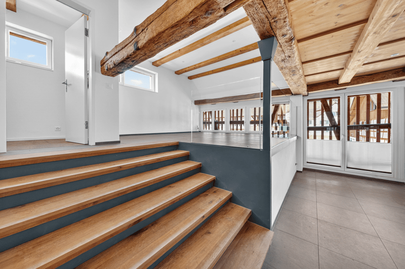 wooden stairs, wooden beams, white walls, glass doors, tiled floor