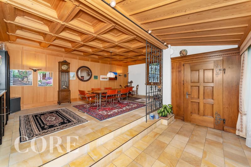 wooden walls, wooden ceiling, dining table, chairs, rug, clock, mirror, potted plant