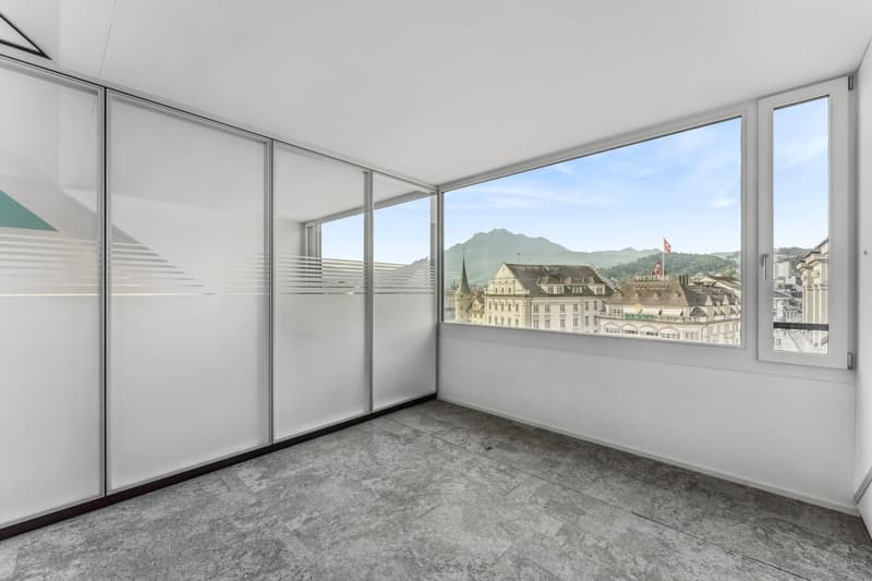 large windows, floor to ceiling glass doors, tiled floor, mountains in the distance