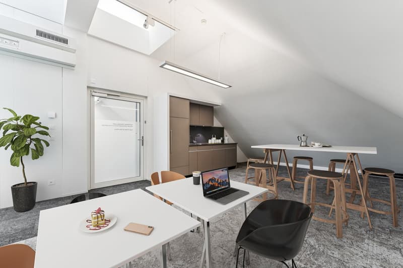 Sleek white walls, wood floor, modern white tables, laptop on a table, modern stools, indoor plant, modern kitchen, lamps