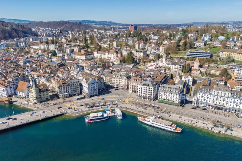 Aerial view of a city with many buildings, a river, and boats docked