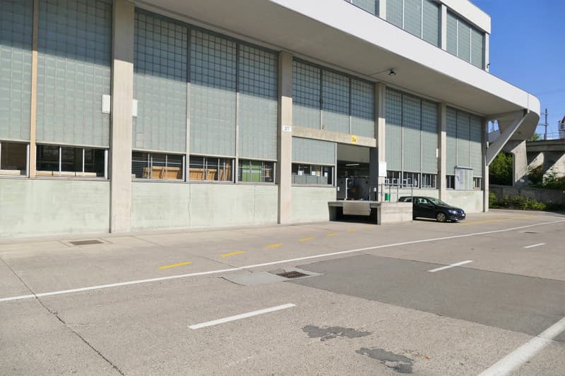 modern design, concrete walls, multiple windows, car parked outside
