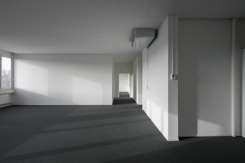 empty room, white walls, dark grey floor, windows, air conditioning