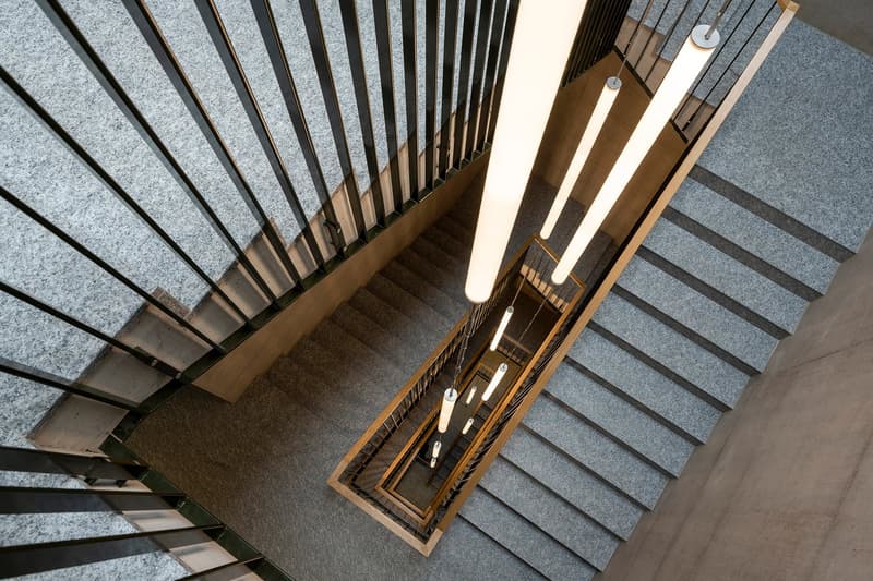 Modern staircase, raised ground floor, steel railings, carpeted steps, hanging cylindrical lights