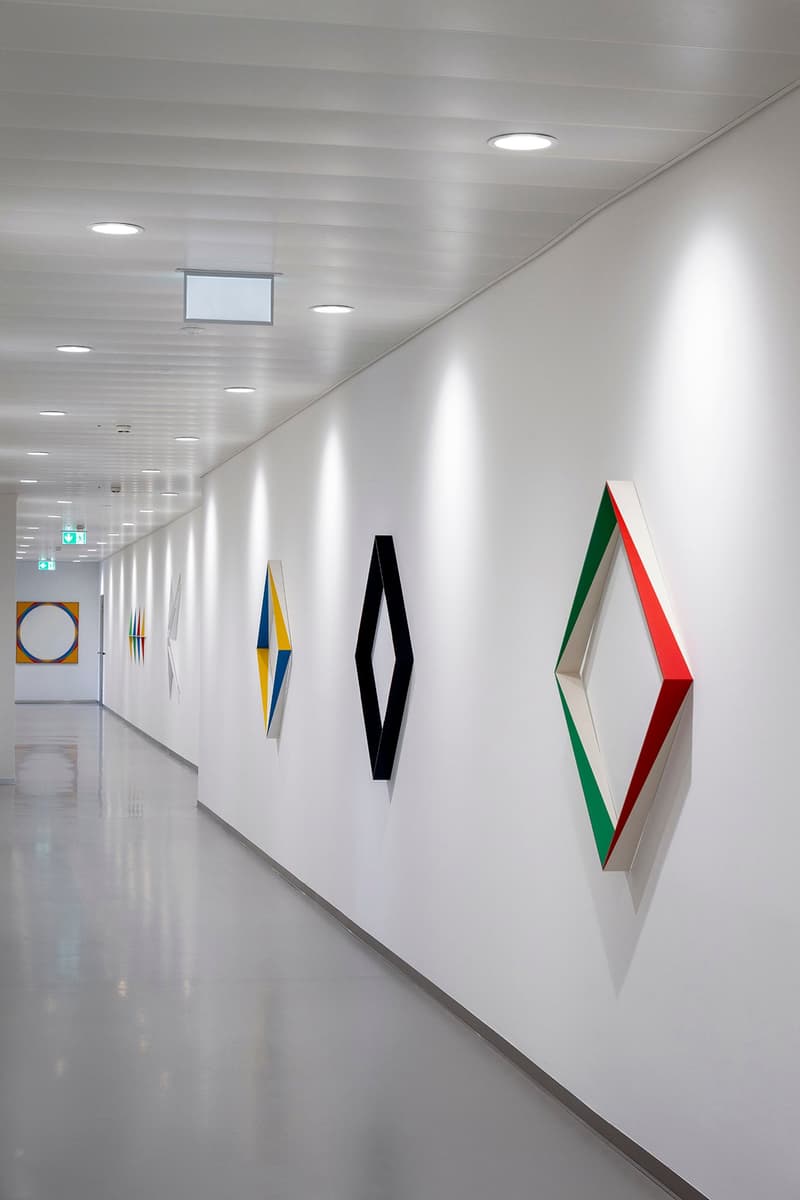 White walls, polished floor, recessed ceiling lights, artwork on the wall