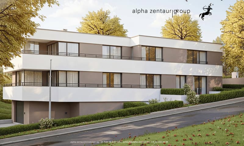 A modern, three-story apartment building with white and brown exteriors. Each floor has a covered balcony, and the entire building sits on a slight slope. The facade is a combination of glass windows and white stucco.