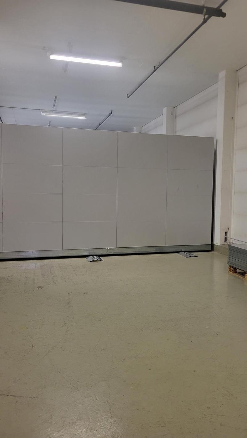 White storage wall, grey floor, long fluorescent light, open space