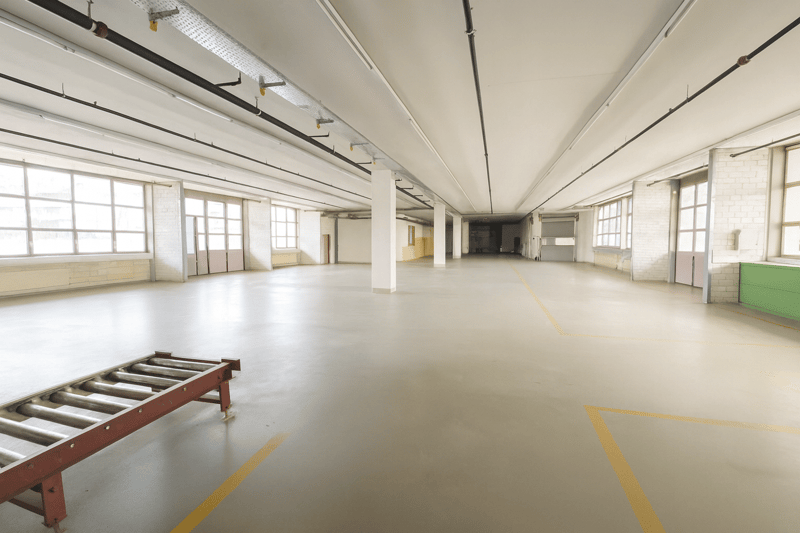 Large open space, industrial design, tall white pillars, windows, empty space