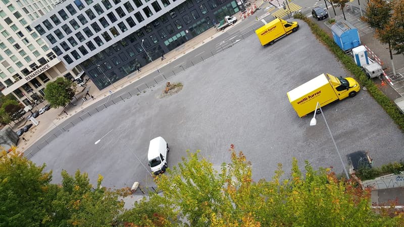 an open parking lot with buildings in the background