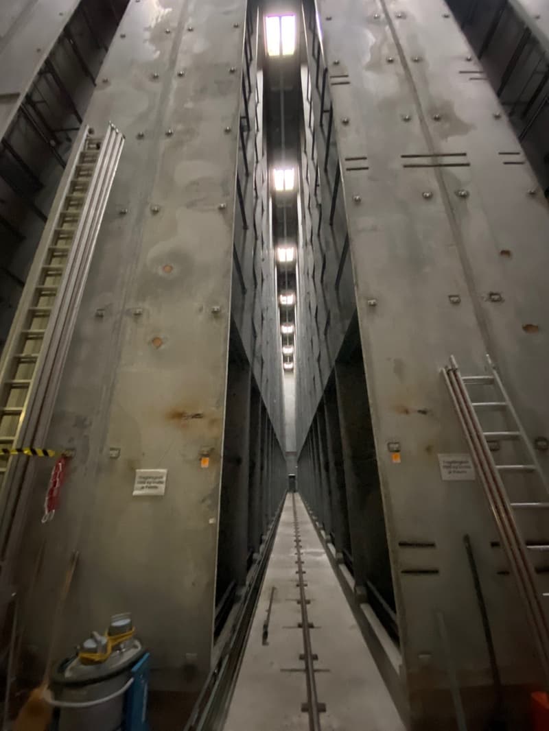 Metal walls, ceiling lights, metal ladders, metal railings, concrete pathway