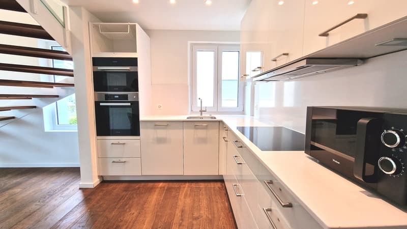 modern kitchen, white cabinets, black appliances, dishwasher, washing machine, windows