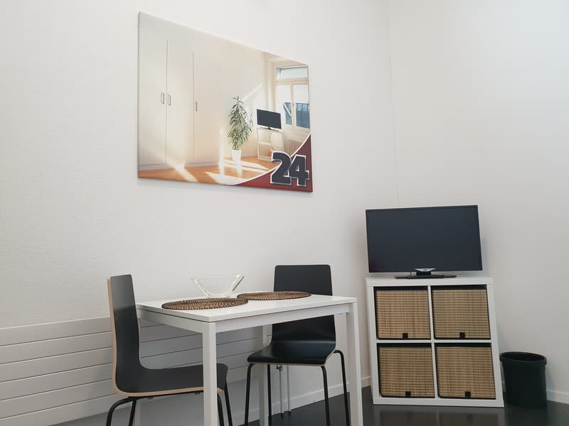 dining area with a table, chairs, cabinet, TV and radiators