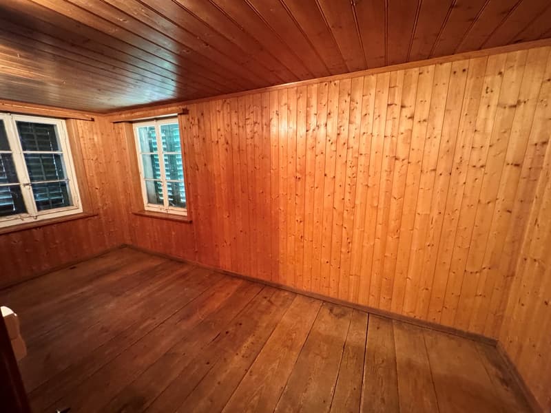 Wooden walls, wooden floor, two windows, no furniture