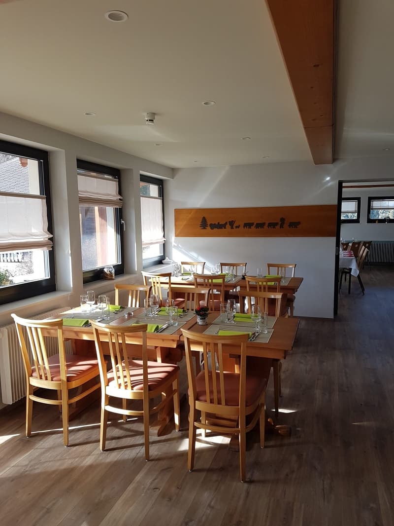 Dining area, wood tables, wooden chairs, tables set for dining, radiators, wooden flooring