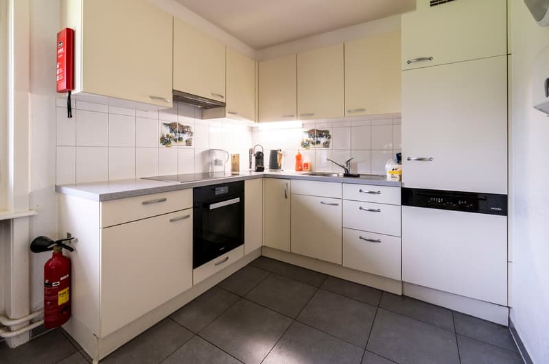 modern design with white cabinetry, granite countertops, electric oven, dishwasher, refrigerator, fire extinguisher