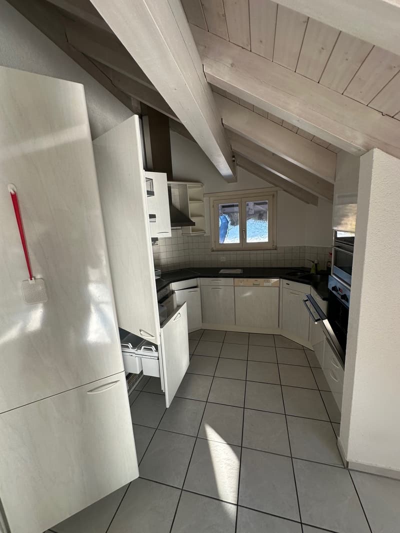 kitchen with white cabinets, black countertops, integrated appliances, tiles floor, a window, wooden beams ceiling