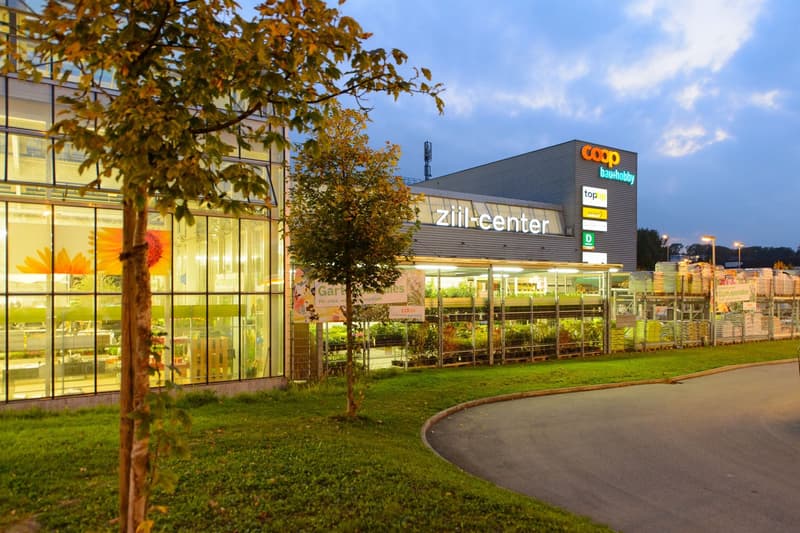 Zill center building with glass walls, plants and trees around