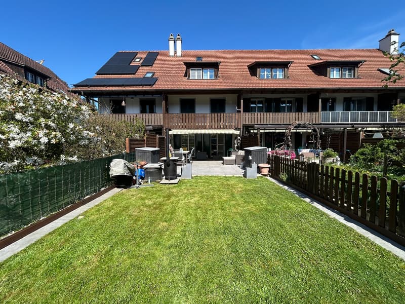 2 story house, brown roof, solar panels, wooden balcony, garden, wooden fence