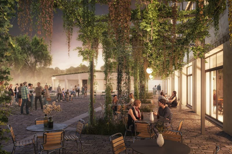 Outdoor seating with brick paths, hanging plants, multiple tables and chairs, large open space, distant building