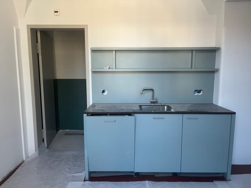kitchen with sink, faucet, cabinets, shelves, and an open door