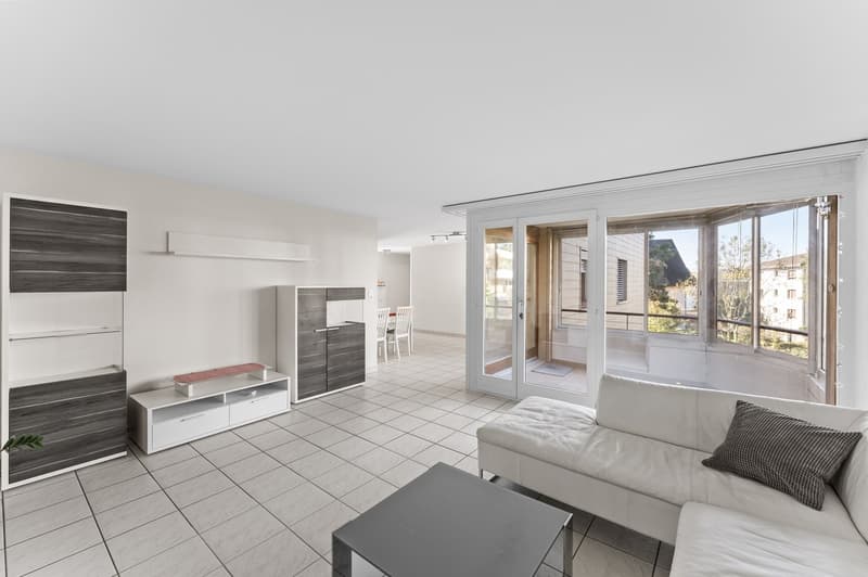 large open space, white leather couch, modern white coffee table, white tiled floor, modern shelving units, balcony