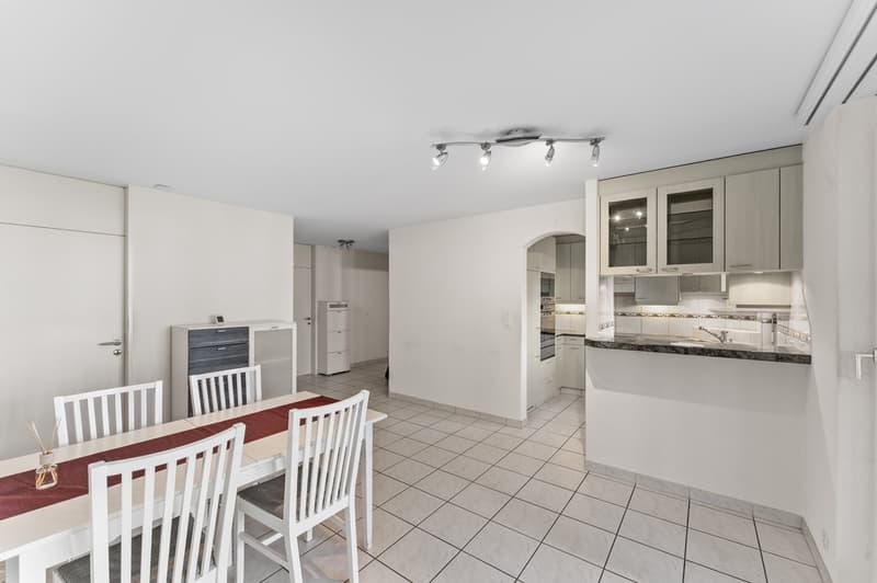 kitchen with tile floor, white furniture, modern appliances, dining table, built-in cabinets, kitchen island with granite countertop, overhead lighting