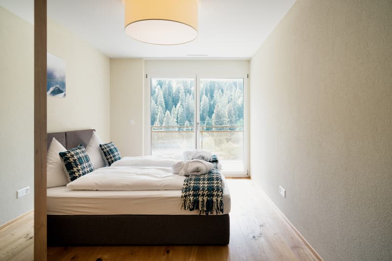 Helles Schlafzimmer mit direktem Zugang zum Balkon und schönem Blick ins Grüne  ein ruhiger Rückzugsort für erholsame Ferienmomente.