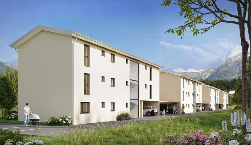 White building, many windows, underground garage, front grass, several cars parked outside