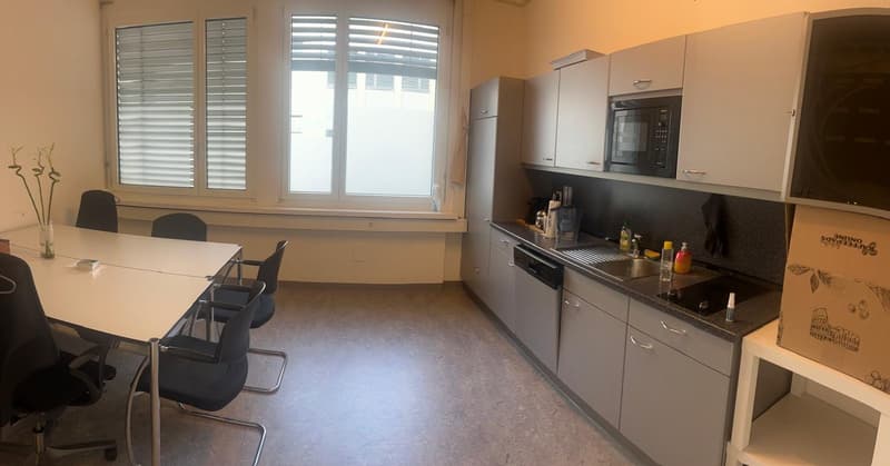 A kitchen with a dining table, chairs, a sink, dishwasher, refrigerator, microwave, cabinets, and a window with blinds.