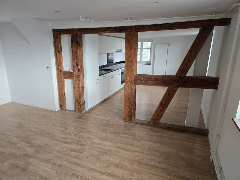 empty room, wooden beams, wooden floor, white kitchen, sink, black countertop, window