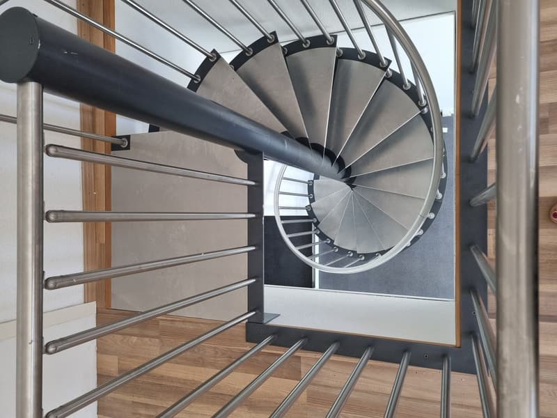 View of a modern spiral staircase made of steel, from the top looking down