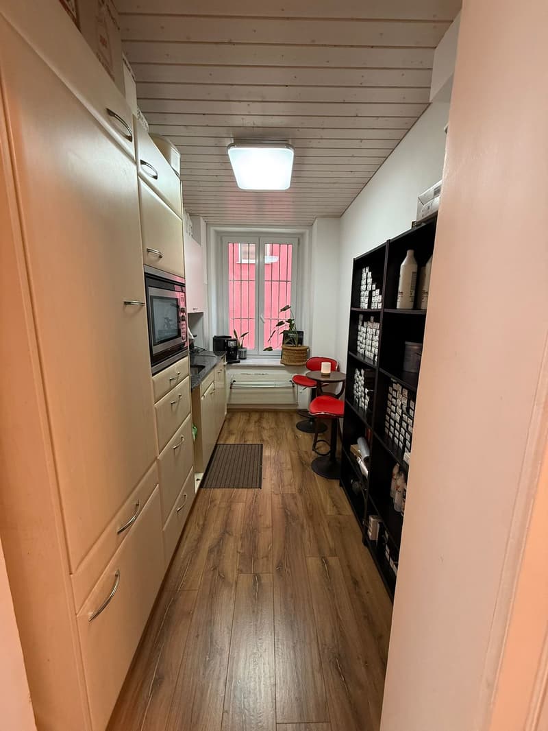 kitchen with microwave, cabinets, countertop, stool, shelf, coffee machine, potted plant