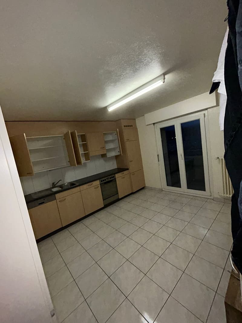 empty kitchen with white tiles, wooden cabinets, sink, oven, sliding door