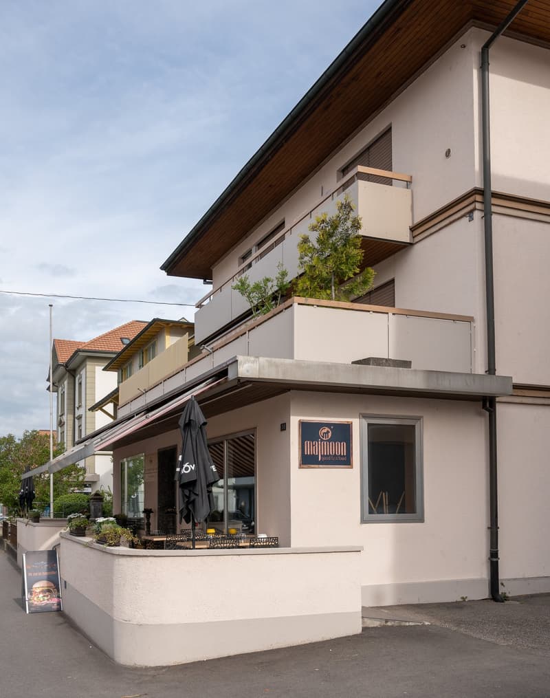 white building, 2 levels, balcony, restaurant, terrace, tree, open parking area