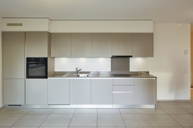 modern kitchen with stainless steel countertops, built-in oven, sink, and dishwasher