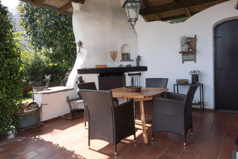 wooden table and chairs, stone wall, fireplace, lamp, terracotta floor