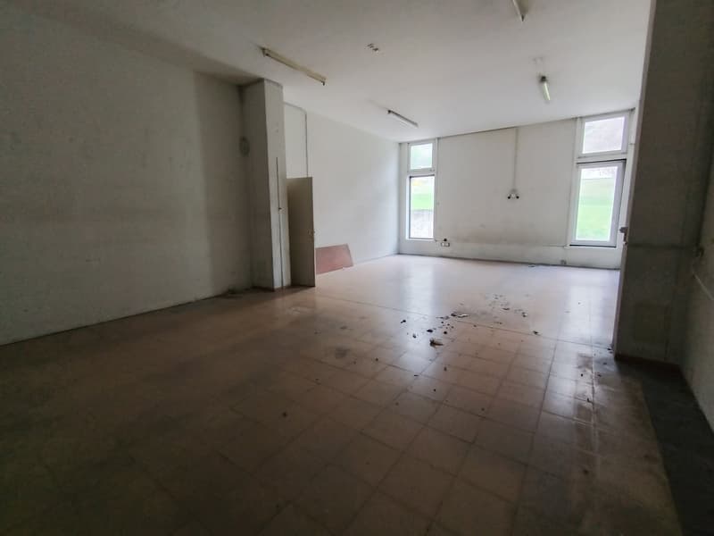 Tiled floor, white walls, fluorescent ceiling lights, and windows