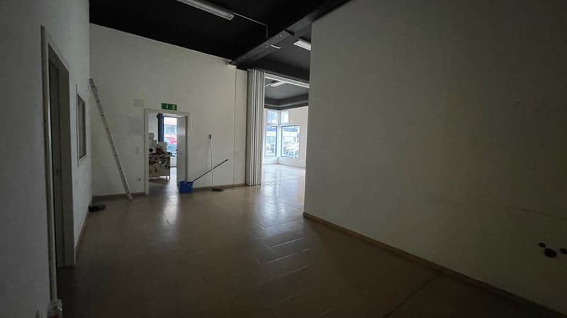 empty room with a tiled floor, a door, an open door, and a ladder and bucket leaning against the wall.