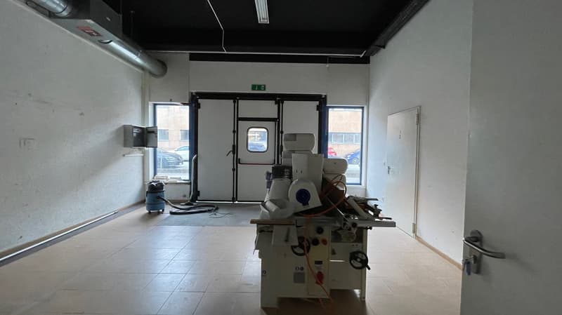 Large workshop room, large door, tiled floor, work machines, vacuum cleaner