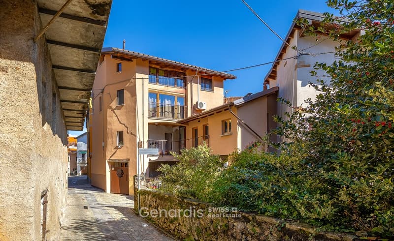 3 story house, beige exterior, multiple windows, balcony, air conditioner, stone wall