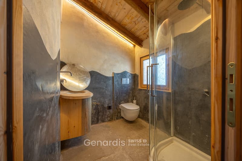 Bathroom with wooden ceiling, concrete walls, wooden sink, toilet, glass shower enclosure