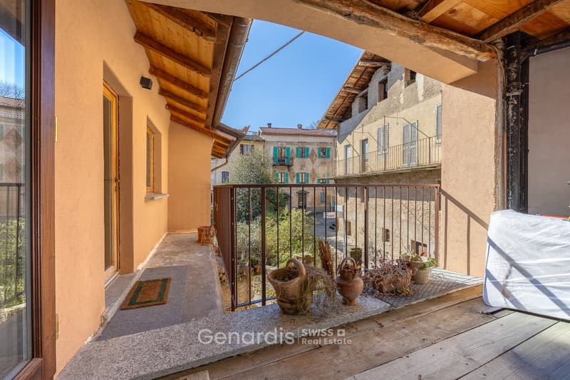 balcony with metal railing, wooden ceiling, potted plants, rug, wooden floor