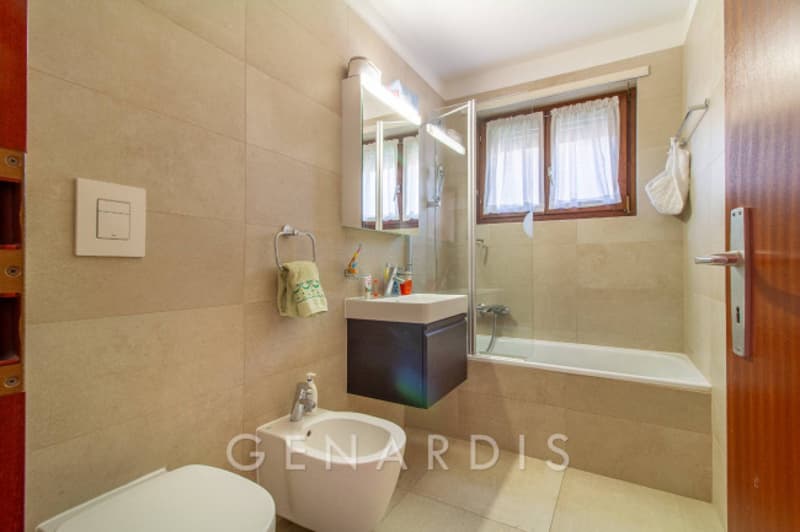 Bathroom with bathtub, shower, sink, toilet, and towel rack