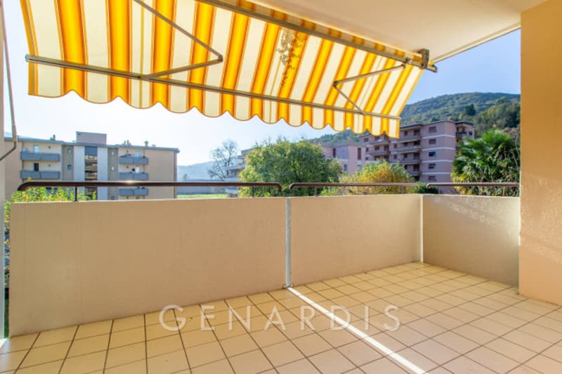 tiled floor, yellow striped awning, balcony, view of mountains and buildings