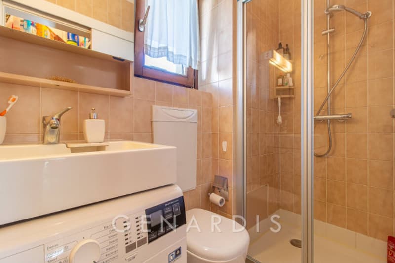 Bathroom with shower, toilet, sink, washing machine, and shelves
