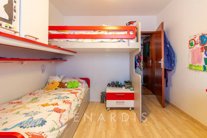Children's bedroom with bunk bed, single bed, nightstand, shelves, and toys