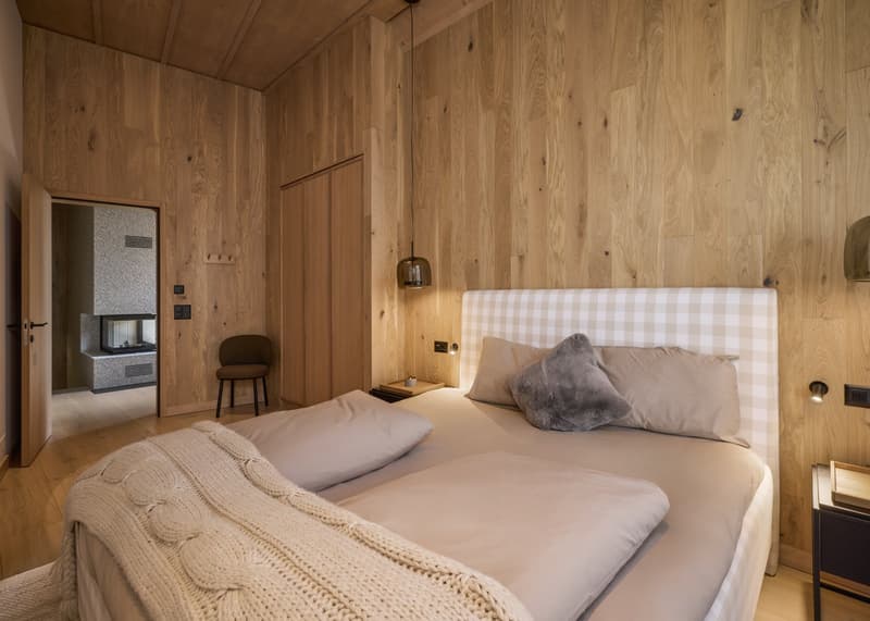 wooden walls, double bed, fireplace in the hallway, chair, bedside table, lamp