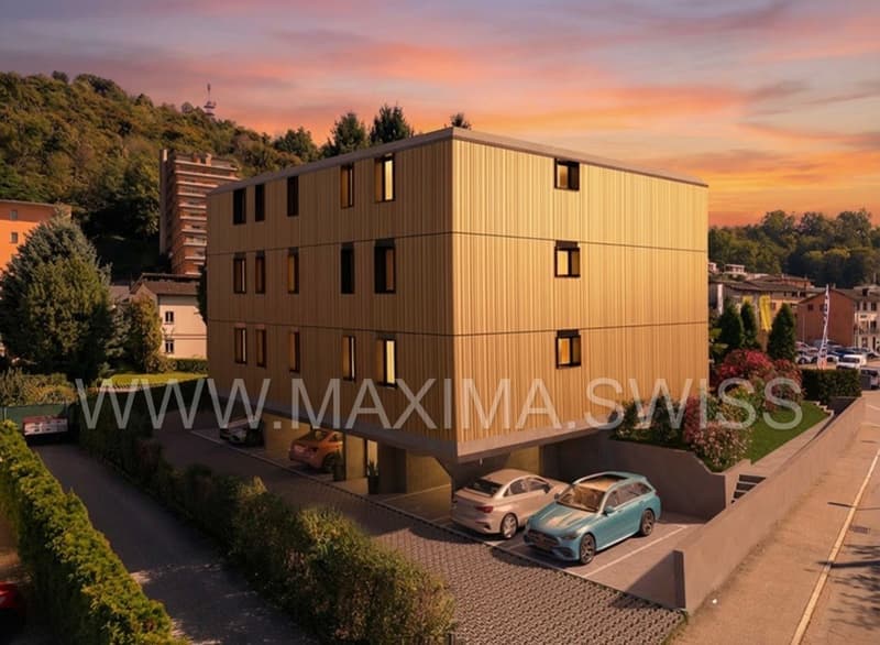 4 story building, yellow exterior, multiple windows, cars parked in front, greenery around