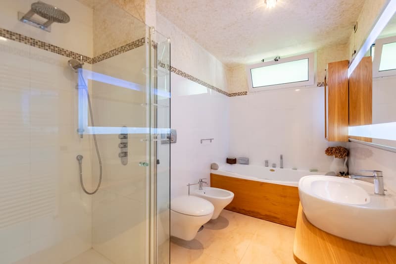 modern bathroom with shower, bathtub, bidet, sink, wooden cabinets, white tiles, wooden floor